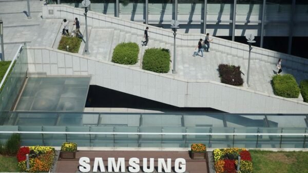 Employees walk past the logo of Samsung Electronics during a media tour at Samsung Electronics' headquarters in Suwon, South Korea, June 13, 2023. REUTERS/Kim Hong-Ji/File Photo