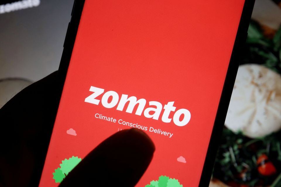 The logo of Indian food delivery company Zomato is seen on its app on a mobile phone displayed in front of its company website in this illustration picture taken July 14, 2021. REUTERS/Florence Lo/Illustration/File Photo